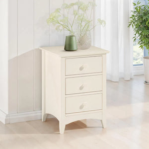 White nightstand with three drawers in a bright room with plants