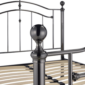Close-up of a metal bed frame with decorative posts on a white background