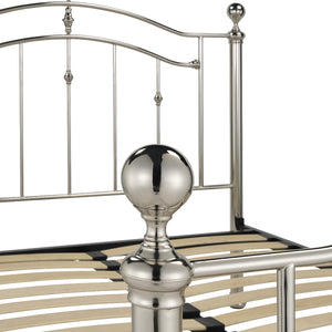 Metal bed frame with decorative posts on a white background