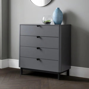 Gray dresser with four drawers against a gray wall.