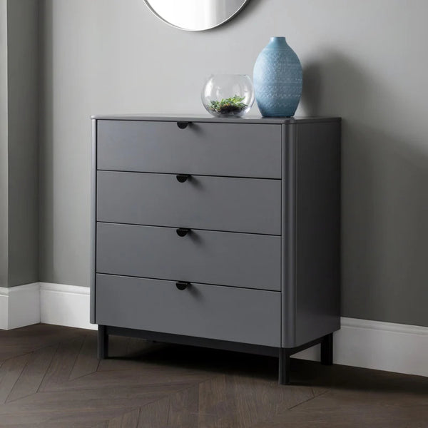 Gray dresser with four drawers against a gray wall.