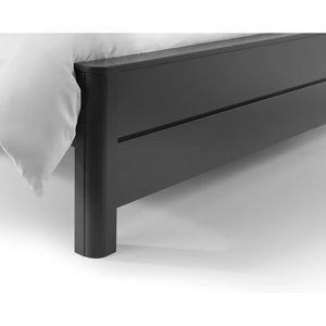 Black bed frame with a white pillow on a white background