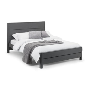 Black bed frame with white bedding and gray throw on a white background