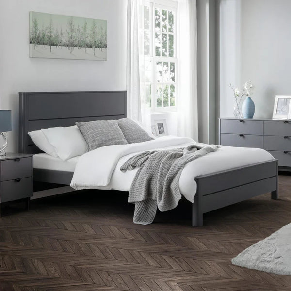 Modern bedroom with gray bed frame, white bedding, and wooden flooring.