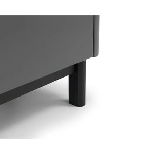 Close-up of a dark gray cabinet corner with a black leg on a white background