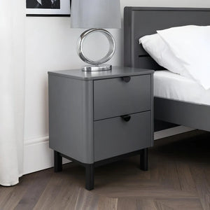 Gray nightstand with a mirror next to a bed in a bedroom setting