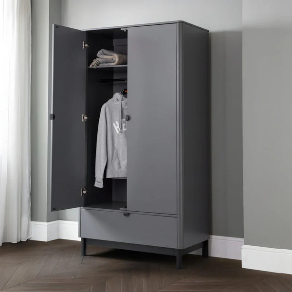 Gray wardrobe with open door showing clothes inside against a gray wall.