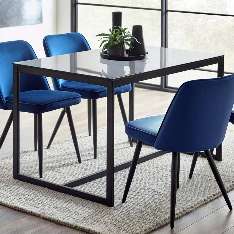 Rectangular dining table with a white top and black metal frame on a white background