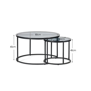 Set of two round glass tables with metal bases, shown with dimensions on a white background.