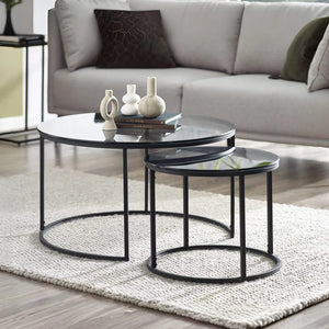 Modern black nesting tables in a living room setting with a sofa and decorative items.