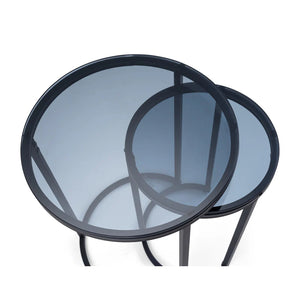 Two round glass tables with black metal frames on a white background
