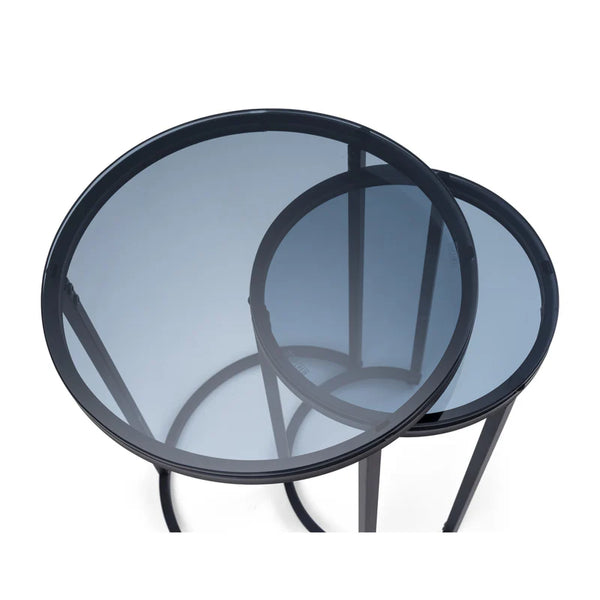 Two round glass tables with black metal frames on a white background