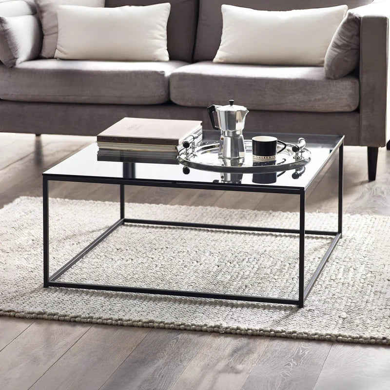 Glass coffee table with black metal frame on a white background
