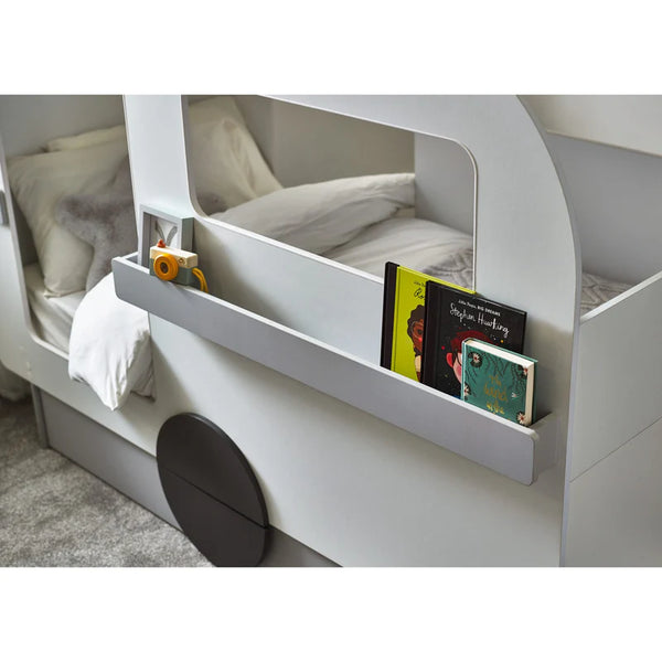 Children's bed with a shelf holding books and a toy car.