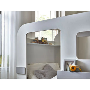 White children's bunk bed with toys in a bright room
