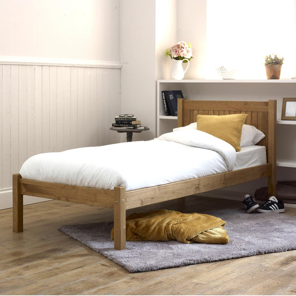 Wooden bed with white bedding and yellow pillows in a bedroom setting.
