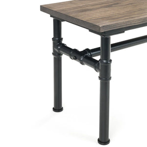 Table with wooden top and black metal pipe legs on a white background
