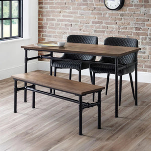 Dining set with table, chairs, and bench against a brick wall.