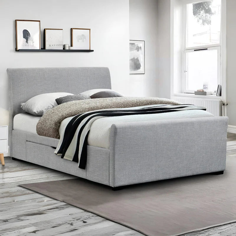 Gray upholstered bed with white bedding and pillows on a white background