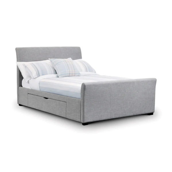 Gray upholstered bed with white bedding and pillows on a white background
