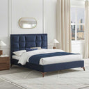 Navy blue upholstered bed in a modern bedroom with white walls and a window.
