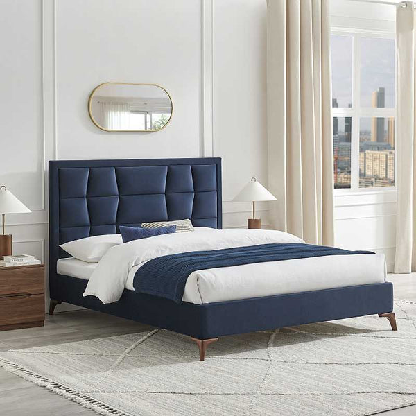 Navy blue upholstered bed in a modern bedroom with white walls and a window.