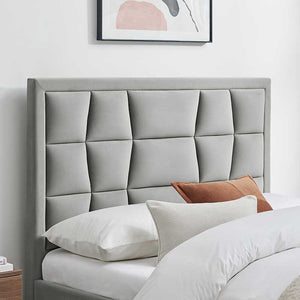 Gray upholstered headboard with pillows in a bedroom setting