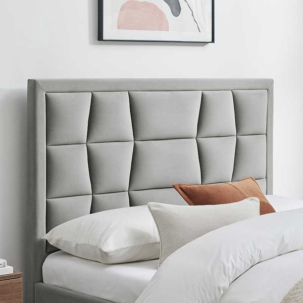 Gray upholstered headboard with pillows in a bedroom setting