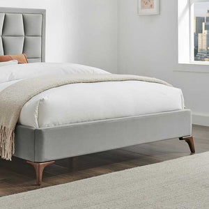 Gray upholstered bed with white bedding in a room with a window and framed picture.