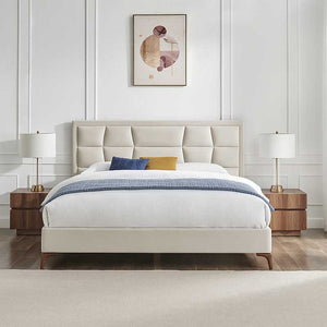 Modern bedroom with a beige upholstered bed, wooden nightstands, and abstract art on the wall.