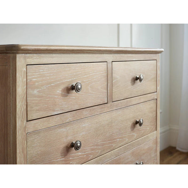 Wooden dresser with three drawers and silver knobs on a white wall background