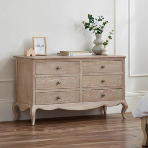 Wooden dresser with decorative items against a white wall