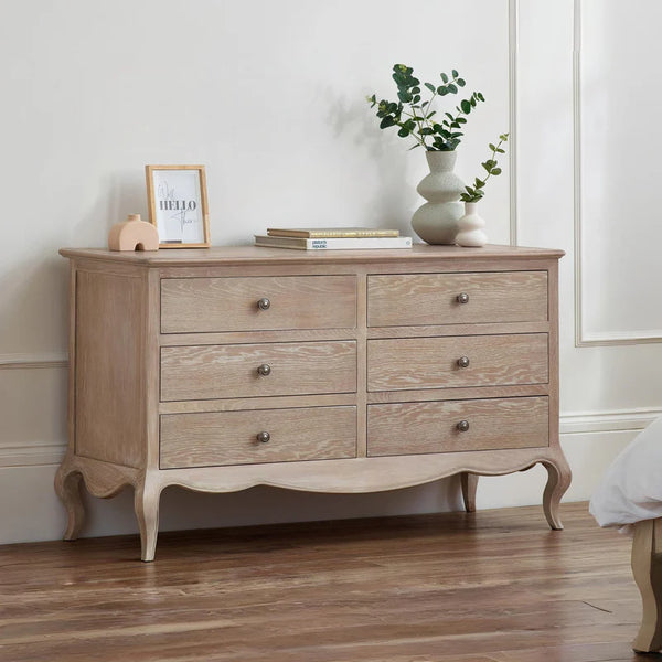 Wooden dresser with decorative items against a white wall