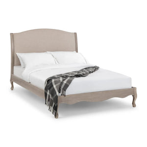 Bed with beige headboard and white bedding on a white background