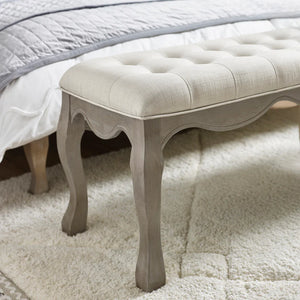 Decorative bench with tufted cushion on a carpeted floor