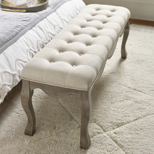 Tufted bench with a cushioned seat in a bedroom setting