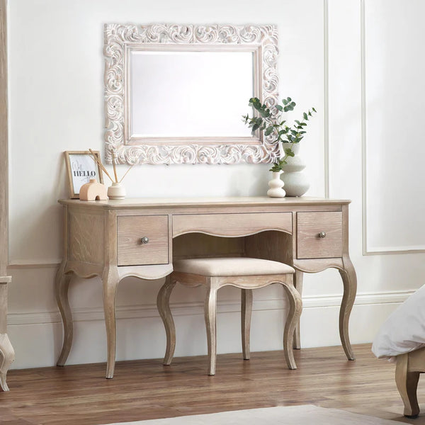 Wooden vanity table with mirror and stool in a room setting