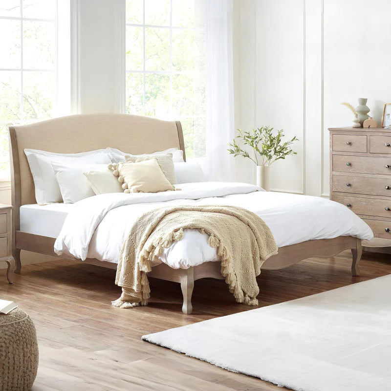 Wooden bed frame with beige headboard on a white background