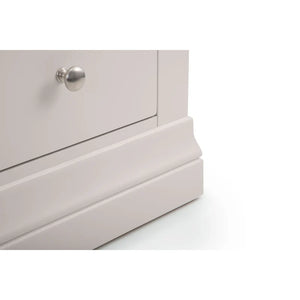 Close-up of a light gray dresser with a silver knob on a white background