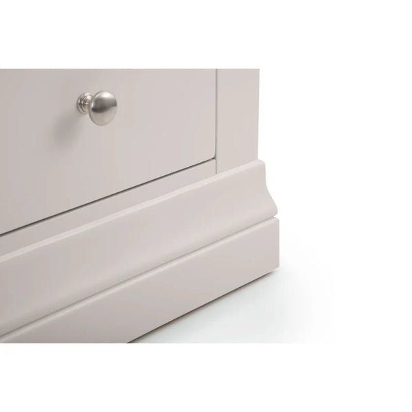 Close-up of a light gray dresser with a silver knob on a white background