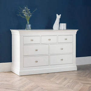 White dresser with decorative items against a blue wall