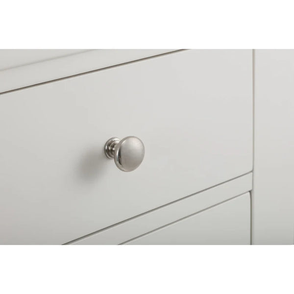 Close-up of a light gray cabinet with a silver knob on a white background