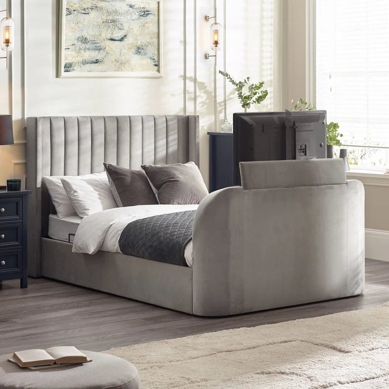 Gray upholstered bed with white bedding and gray pillows on a white background