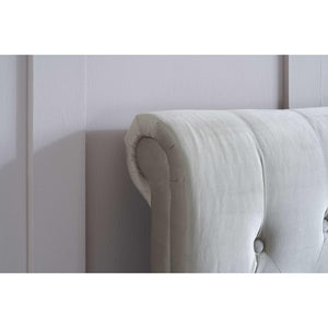 Beige upholstered headboard against a white wall