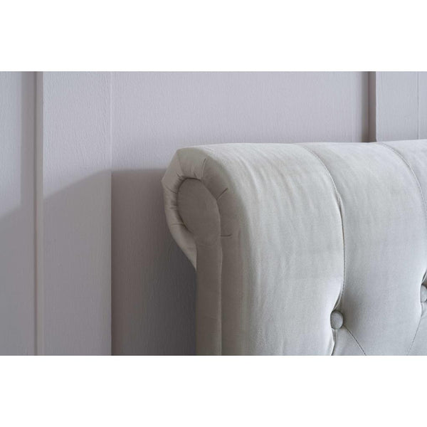 Beige upholstered headboard against a white wall