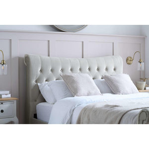 White upholstered bed with matching headboard in a bedroom setting.