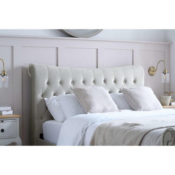 White upholstered bed with matching headboard in a bedroom setting.