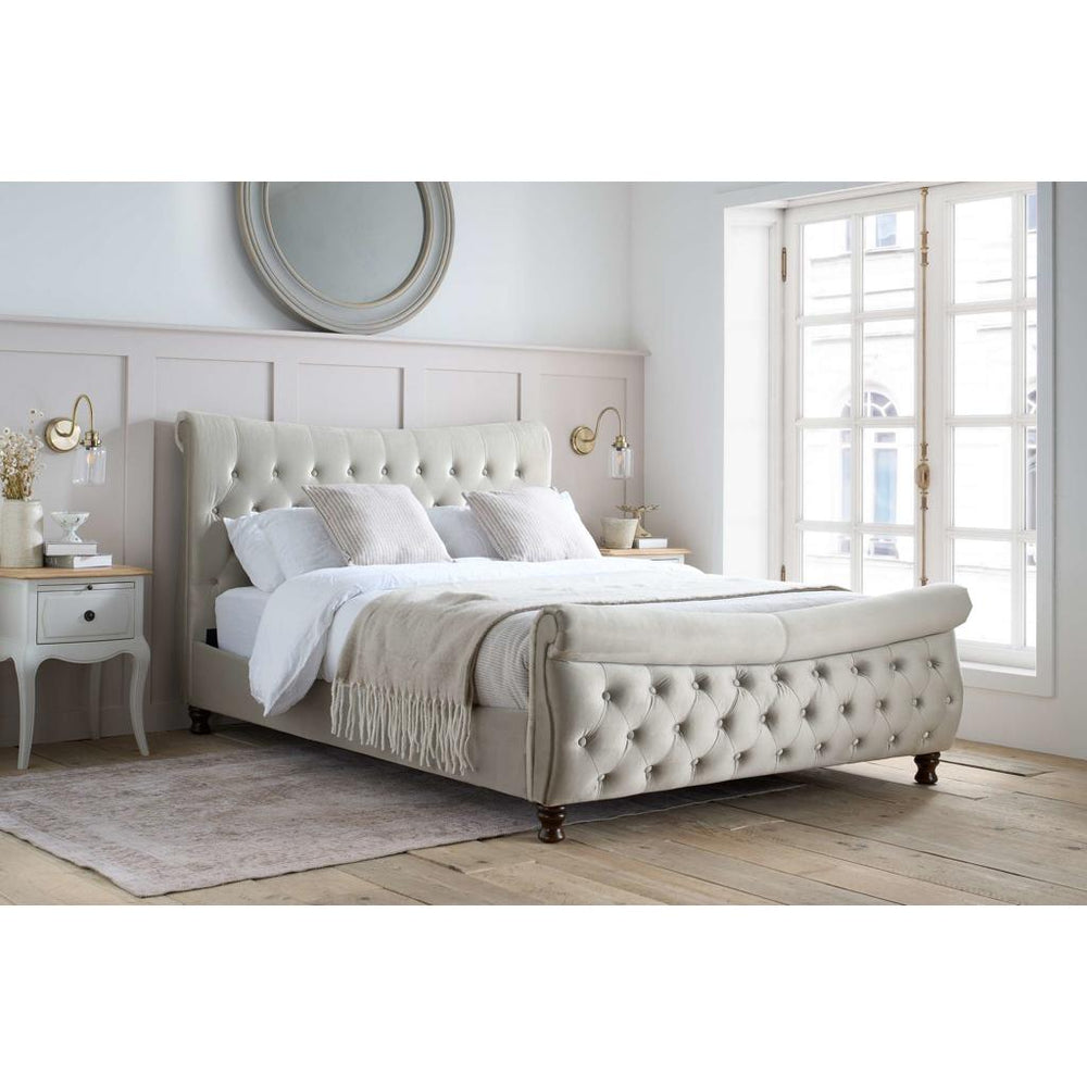 Beige upholstered bed with tufted details on a white background