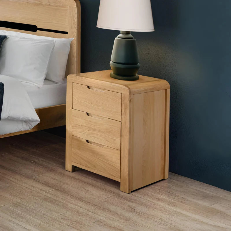 Wooden nightstand with three drawers on a white background