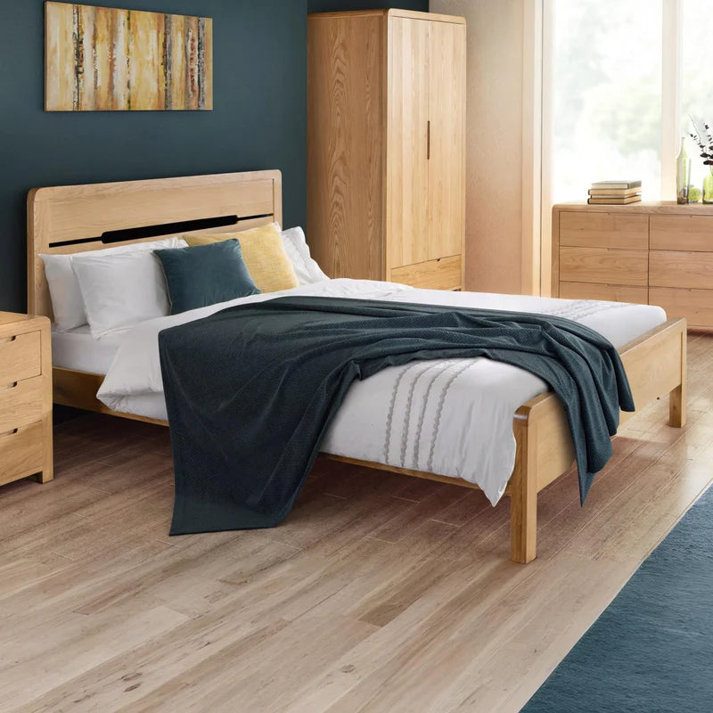 Wooden bed frame with bedding on a white background